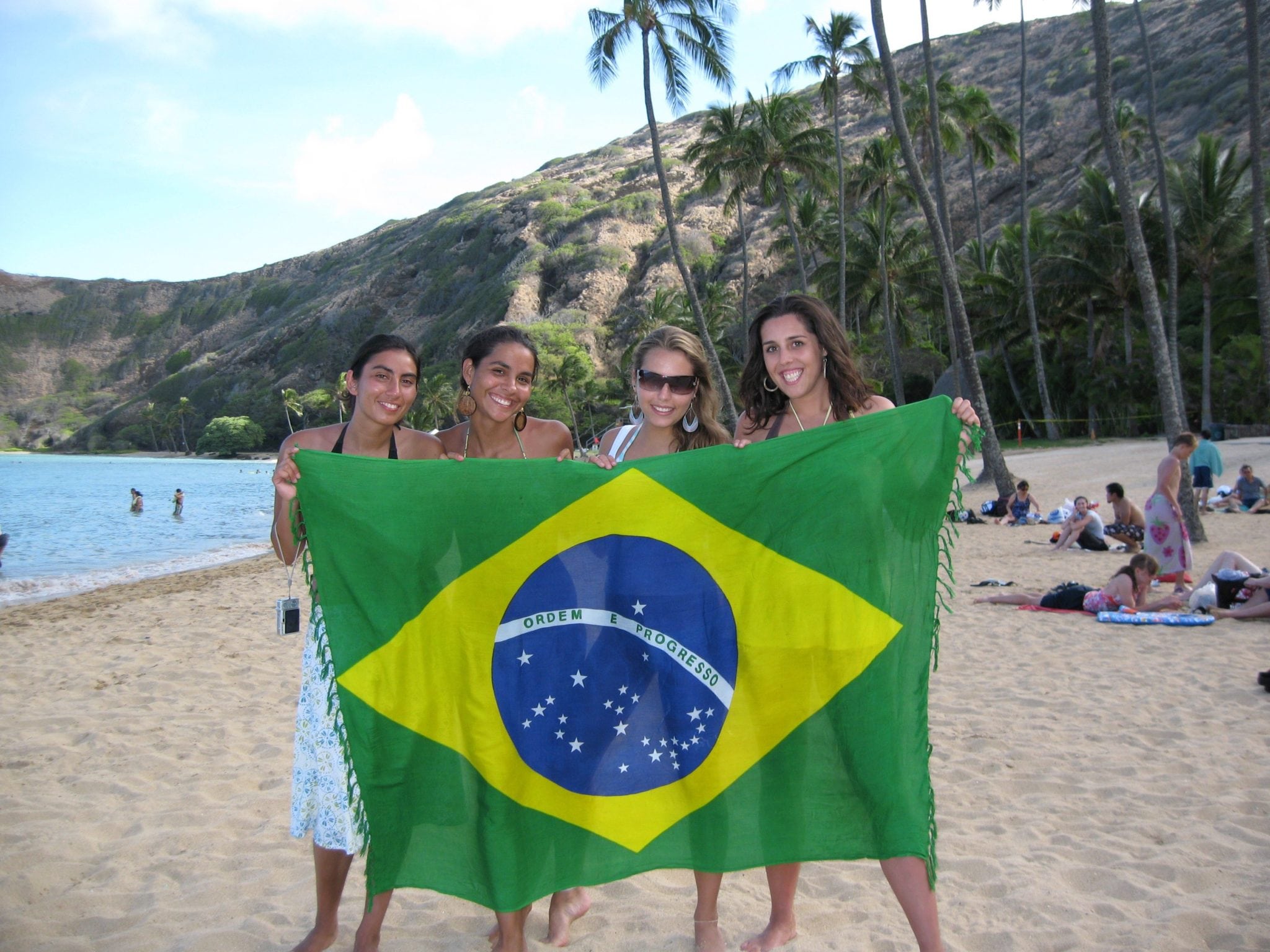 Women on beach with Brazilian flag
