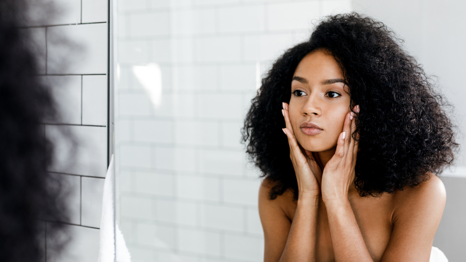 Woman Looking in a Mirror Practicing Skin Care